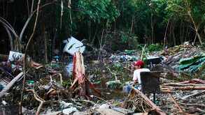 un hombre sentado entre varios escombros por una inundación