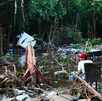 un hombre sentado entre varios escombros por una inundación un hombre sentado entre varios escombros por una inundación