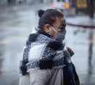 Mujer caminando con cubrebocas con lluvias y bajas temperaturas en la Ciudad de México.