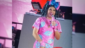 La Gaby Mendoza sosteniendo un micrófono mientras da un espectáculo.