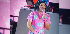 La Gaby Mendoza sosteniendo un micrófono mientras da un espectáculo.