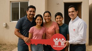 Familia mexicana, papá, mamá, hija e hijo, posan frente a su nueva casa en remate comprada con un crédito Infonavit.