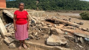 Señora damnificada junto a su vivienda destruida por las inundaciones en Huautla, Hidalgo.