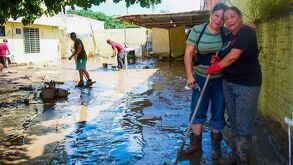 Dos mujeres realizan labores de limpieza en sus casas, luego de que fueran cubiertas por el lodo, agua y basura de la corriente del río Cazones en Poza Rica.