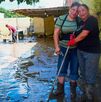 Dos mujeres realizan labores de limpieza en sus casas, luego de que fueran cubiertas por el lodo, agua y basura de la corriente del río Cazones en Poza Rica.