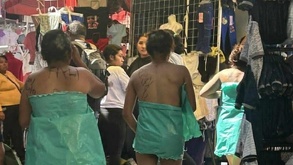 Tres mujeres desnudas se cubren con bolsas mientras caminan en tianguis de Texmelucan.