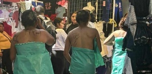 Tres mujeres desnudas se cubren con bolsas mientras caminan en tianguis de Texmelucan.