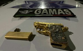 Pistola con chapa y cartucho de oro sobre cofre patrulla de escuadrón Gamas