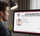 Joven observa la pantalla de su computadora mientras tramita su CURP biométrica, misma que puede descargarse en línea.