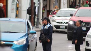 Mujer tránsito inspeccionando un automóvil en las calles de Chihuahua.