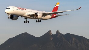 Avión de Iberia volando sobre Monterrey con el Cerro de la Silla de fondo
