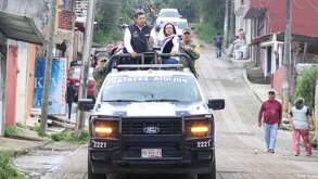 Personas arriba de una patrulla de policía estatal en la Sierra Norte de Puebla, tras fuertes lluvias.