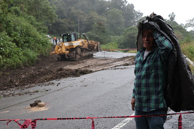 Hombre frente a una carretera destruida por las fuertes lluvias en la Sierra Norte de Puebla. Hombre frente a una carretera destruida por las fuertes lluvias en la Sierra Norte de Puebla.