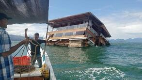 un restaurante de madera flotando en el mar abierto y unos pescadores