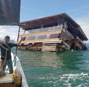 un restaurante de madera flotando en el mar abierto y unos pescadores