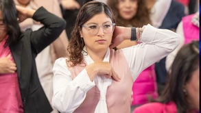 Mujer explorándose para detectar cáncer de mama.