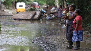 una pareja de adultos mayores cargando a un bebé tras los deslaves en la sierra norte de puebla