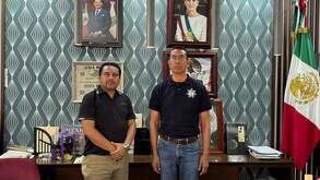 dos hombres tomándose una fotografía en una oficina