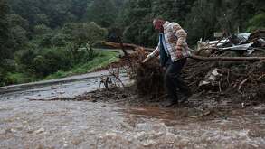un hombre entre escombros por lluvias en puebla