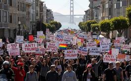 Grupo de manifestantes con carteles anti Trump