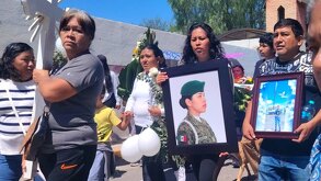 Personas caminan en un sepulcro con imágenes de Stephany Carmona, joven poblana asesinada en la Guardia Nacional.