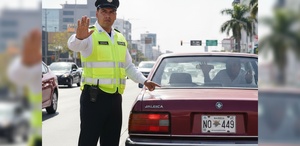 Agente de tránsito deteniendo a coche con placas antiguas de Jalisco