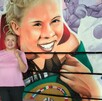 Una mujer en playera rosa posa frente a un mural de boxeo vibrante que muestra a una campeona sonriente con un cinturón. Se aprecian las cuerdas y esquinas Una mujer en playera rosa posa frente a un mural de boxeo vibrante que muestra a una campeona sonriente con un cinturón. Se aprecian las cuerdas y esquinas