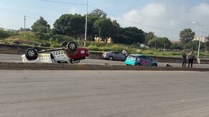 Una camioneta de Policía Municipal volcada de lado en una carretera de El Salto, Jalisco. Un coche azul con logo de 