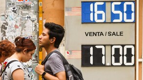 Gente caminando frente a un banco de cambio.