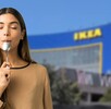 Mujer probando un platillo con el edificio de IKEA de fondo Mujer probando un platillo con el edificio de IKEA de fondo