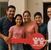 Familia mexicana, papá, mamá, hija e hijo, posan frente a su nueva casa en remate comprada con un crédito Infonavit.
