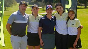 La golfista Lorena Ochoa con gorra azul y polo oscuro realiza un swing en un campo de golf. Detrás de ella hay un cartel con logos de patrocinadores.