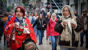 dos mujeres abrigadas tomando una bebida caliente por un frente frío en méxico