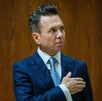 Retrato del político Pablo Lemus con traje azul y corbata clara, con la mano sobre el pecho. Mira hacia su derecha con expresión seria. Fondo de pared de madera Retrato del político Pablo Lemus con traje azul y corbata clara, con la mano sobre el pecho. Mira hacia su derecha con expresión seria. Fondo de pared de madera