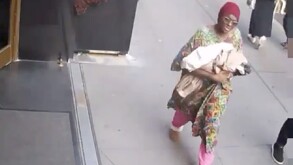 Mujer caminando con una bebé en brazos, momentos previos a abandonarla en una estación del metro de Nueva York.