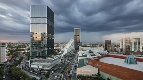 Panorámica de la zona Puerta de Hierro de Guadalajara al atardecer, bajo un cielo nublado y dramático. Se aprecia la torre Puerta Hierro con su arquitectura mod