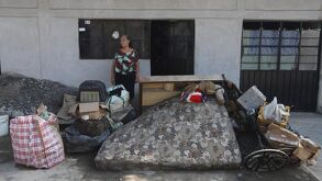 una mujer afuera de una casa inundada por las lluvias en la sierra norte de puebla