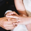 En la imagen se pueden ver las manos de un hombre poniendo el anillo de bodas a su prome En la imagen se pueden ver las manos de un hombre poniendo el anillo de bodas a su prome