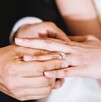 En la imagen se pueden ver las manos de un hombre poniendo el anillo de bodas a su prome En la imagen se pueden ver las manos de un hombre poniendo el anillo de bodas a su prome