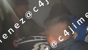 Policías sacando a la mujer golpeada por su esposo de su casa incendiada en Tláhuac.