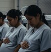 Cuatro mujeres embarazadas migrantes con uniformes grises idénticos, sentadas en una hilera tocando sus vientres. El fondo sombrío sugiere una detención Cuatro mujeres embarazadas migrantes con uniformes grises idénticos, sentadas en una hilera tocando sus vientres. El fondo sombrío sugiere una detención