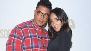 En la imagen aparece Jawy Méndez abrazando a Manelyk González, la pareja aparece en un fondo blanco con logos de algunas marcas.