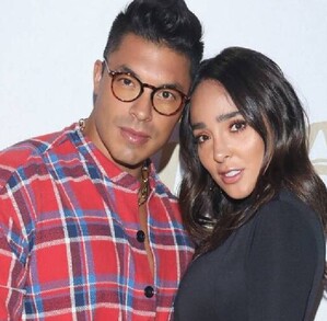 En la imagen aparece Jawy Méndez abrazando a Manelyk González, la pareja aparece en un fondo blanco con logos de algunas marcas.