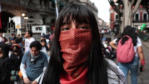 Mujer con un paliacate que le cubre la mitad del rostro en el zócalo de la ciudad de Puebla.