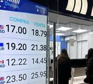 Ventanilla de cambio con gente comprando dólares.