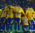 El equipo de Tigres formado junto a una imagen de la última victoria de Xolos en el Volcán, con gol de Dayro Moreno.