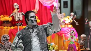 Hombre vestido de catrín que se encuentra presentando una de las ofrendas que participan en el corredor de ofrendas en Puebla.