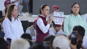 claudia sheinbaum con un micrófono hablando a habitantes de poza rica en veracruz