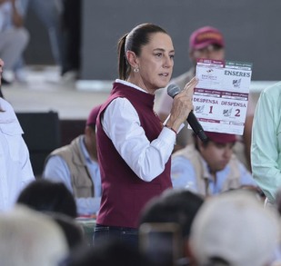 claudia sheinbaum con un micrófono hablando a habitantes de poza rica en veracruz