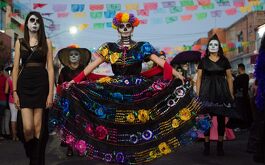 Mujeres maquilladas como catrina en desfile de Día de Muertos en Tlaquepaque